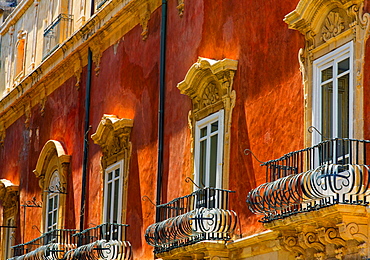 Facade of a residential building with ornate balconies and corbels, Syracuse, Sicily, Ortigia, Italy