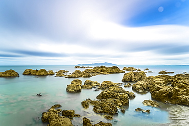 Rocks in the ocean along the shoreline in Pukerua Bay, Kapiti Island, Wellington, New Zealand