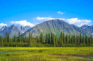 Clouds rolling across mountain peaks in the Talkeetna Range in South-central Alaska on a sunny summer day, Alaska, United States of America