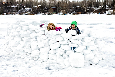 Children playing in a snow fort on frozen Lake Wabamun, Wabamun, Alberta, Canada