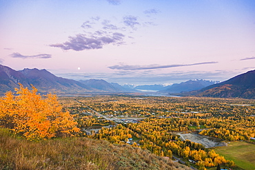 View of the moon rising above Palmer and the Knik River from atop the Butte, the Chugach Mountains in the background during twilight on a clear evening, South-central Alaska, Palmer, Alaska, United States of America