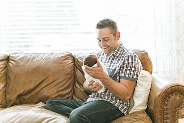 Portrait of a father holding his newborn baby, Surrey, British Columbia, Canada