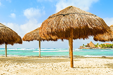 Grass beach umbrellas next to the Caribbean ocean, Playa Del Carmen, Quintana Roo, Mexico