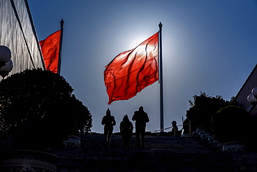 Silhouettes of people and flag in Tiananmen Square, Beijing, China