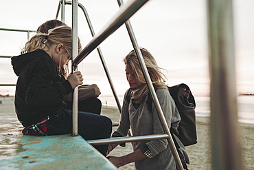 A mother with her daughters at a lifeguard station at dawn, Long Beach, California, United States of America