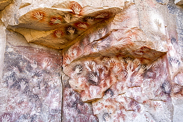 Colourful handprints on a rock face, ochre-ink art made by the long-vanished Toldense People, Santa Cruz, Argentina