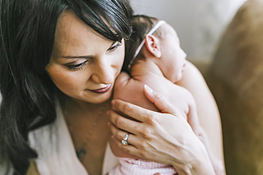 Newborn baby in mother's arms at home, Surrey, British Columbia, Canada