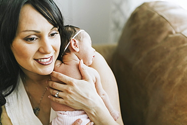 Newborn baby in mother's arms at home, Surrey, British Columbia, Canada