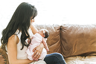 Newborn baby in mother's arms at home, Surrey, British Columbia, Canada