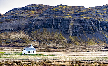 A church and small graveyard are dwarfed by the surrounding nature in Western Iceland, Iceland