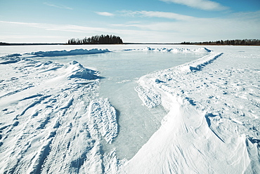 Snow drifted and cleared on a frozen lake in Elk Island National Park, Alberta, Canada