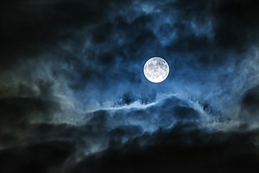 Bright full moon glowing in a cloudy sky, Ontario, Canada