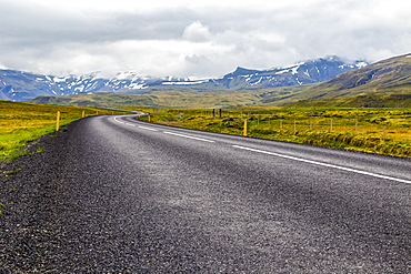 The open highway leads into the mountain landscape in Western Iceland, Iceland