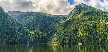 Scenic view of the Great Bear Rainforest area with a sailboat on the water, Hartley Bay, British Columbia, Canada