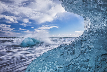 Blue ice and icebergs with water splashing at Jokulsarlon, South coast, Iceland