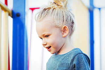 Close-up of a young girl with blond hair playing in a playground on a warm fall day, Spruce Grove, Alberta, Canada