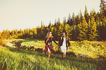 Young couple walking together beside a creek in a city park, Edmonton, Alberta, Canada