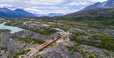 A train runs through the barren landscape on its way to Carcross, Yukon Territory, Canada