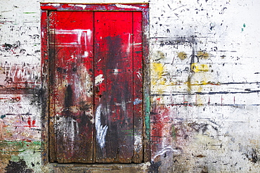 Red wooden doors and wall splattered with multiple paint colours, Nicaragua