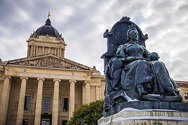 A sculpture of Queen Victoria with the Manitoba Legislative Building in the background with a statue of the Golden Boy on top, Winnipeg, Manitoba, Canada