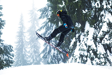 A teenage boy snowboarding on Mount Seymore, North Vancouver, Vancouver, British Columbia, Canada