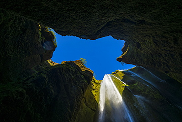 Looking up to a small waterfall in large hole near Seljalandsfoss, Iceland