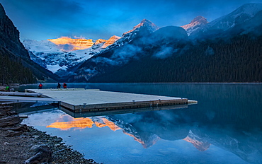 Peaks of the Rocky Mountains illuminated by sunlight and reflected in Lake Louise, Lake Louise, Alberta, Canada