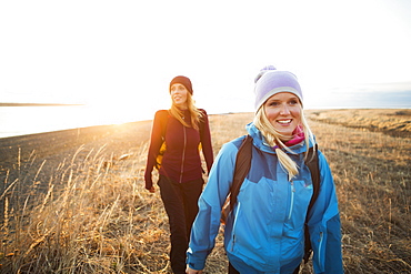Two young women hiking along the coast at sunrise, Anchorage, Alaska, United States of America