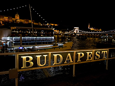 Szechenyi Chain Bridge over the Danube River and sign for Budapest illuminated at nighttime, Budapest, Budapest, Hungary