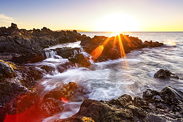 Dramatic sunset over the ocean with waterfalls along the rugged coastline, Wailea, Maui, Hawaii, United States of America