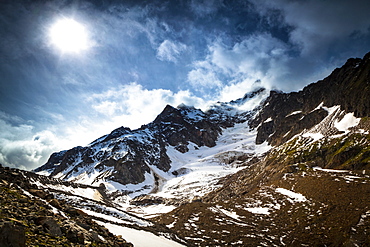 Storm clouds over Aiguille des Glaciers (mountain) and Estellette Glacier and moraine, Alps, Aosta Valley, Italy