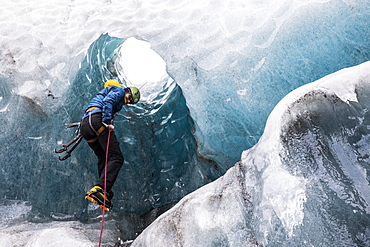 Man exploring an ice cave, South Coast, Iceland