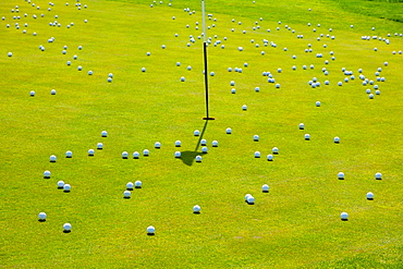 Numerous golf balls by a hole on golf course, creating chaos, Lucerne, Lucerne, Switzerland