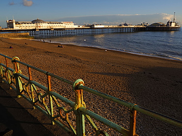 View of Brighton Pier and beach at sunset, Brighton, East Sussex, England