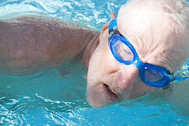 Close-up of a senior man swimming in a swimming pool