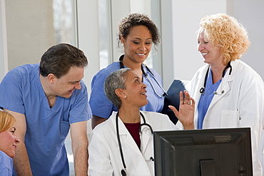 Doctors and nurses consulting on a computer in hospital