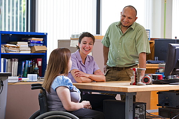 Engineering student with Spina Bifida discussing transmitter and flow meter sensors with her classmate at engineering lab bench