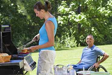 Man with spinal cord injury in wheelchair enjoying picnic with his wife