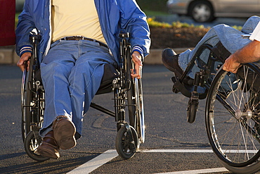 Man with Friedreich's Ataxia greeting his friend with spinal cord injury