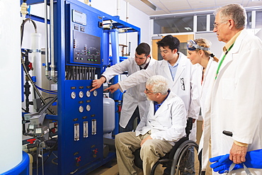 Professors explaining operation of water ultra purification system to engineering students in a laboratory