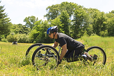 Man with spinal cord injury riding on off-road hand cycle