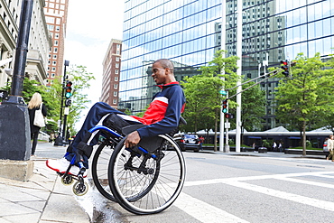 Man in wheelchair who had Spinal Meningitis going over a curb