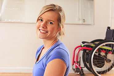 Young woman with a spinal cord injury with wheelchair in a yoga studio