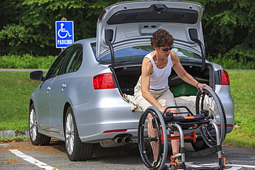 Woman with Spinal Cord Injury taking her wheelchair out of her car