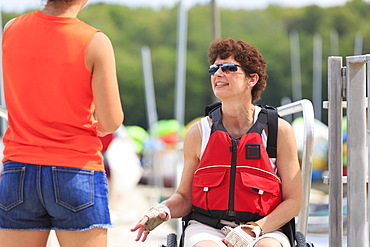 Woman with a Spinal Cord Injury talking to an instructor about using a kayak