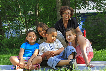 Happy Hispanic family with Autistic boy sitting together in a park