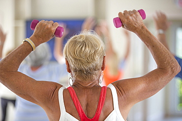 Rear view of senior woman exercising in gym