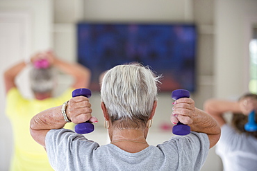 Rear view of senior woman exercising in gym