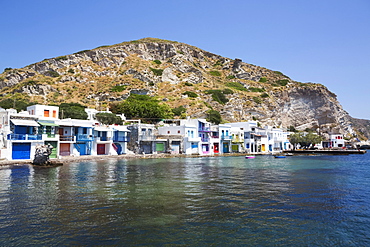 Klima village with white houses and colourful accents along the water's edge; Klima, Milos Island, Cyclades, Greece