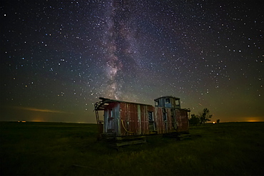 Old caboose at nighttime under a bright, starry sky; Coderre, Saskatchewan, Canada